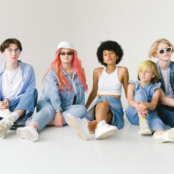 Group of diverse teenagers sitting together and smiling.
